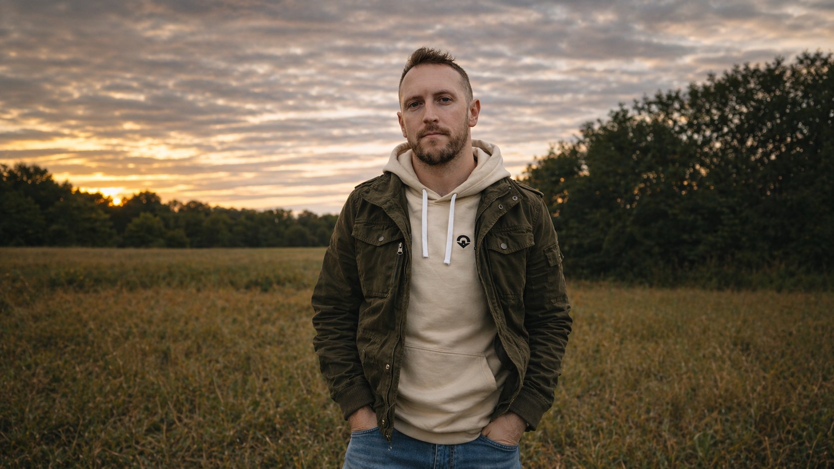 Kevin Crider, senior software developer, standing in a field at sunset
